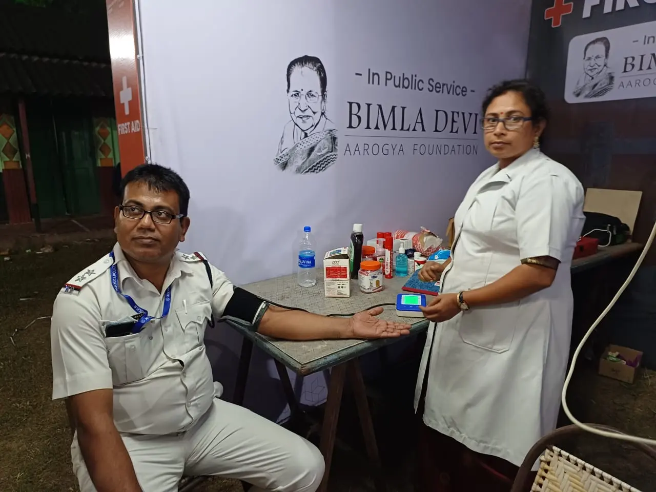 A BDAF nurse checking a police officer’s blood pressure at a Durga Puja camp