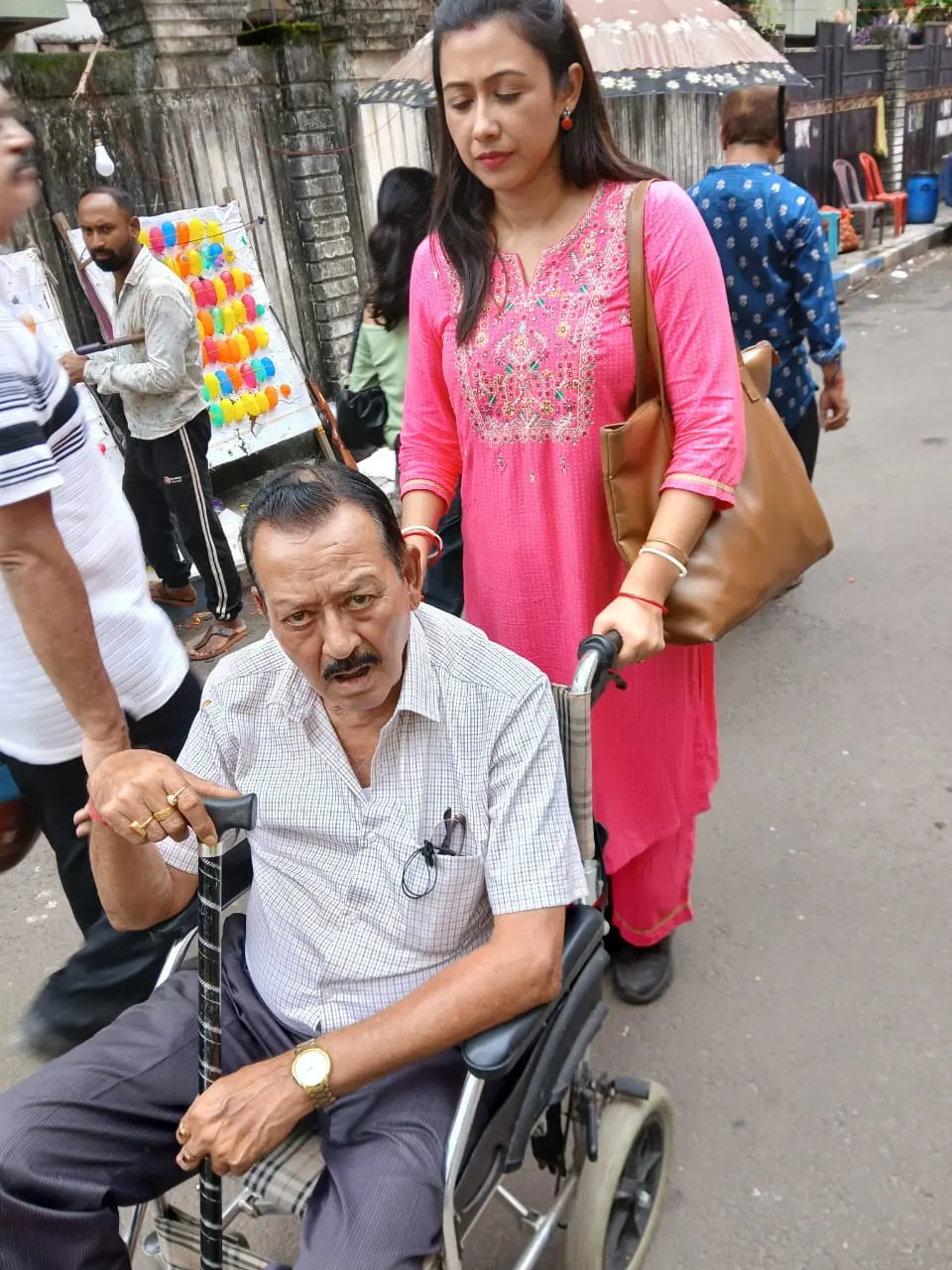 A visitor brought by wheelchair to a BDAF Durga Puja health camp